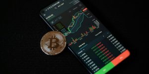 a bitcoin sitting on top of a smart phone