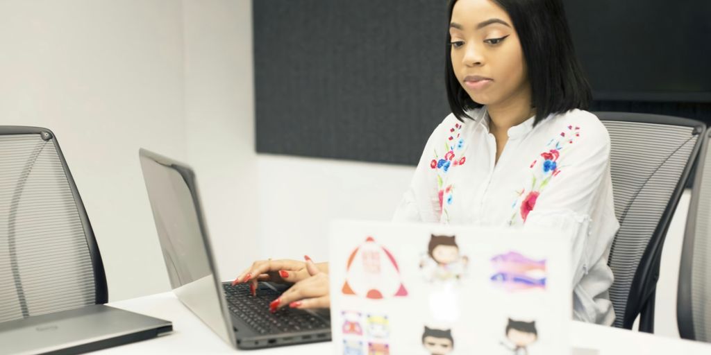 a woman sitting in front of a laptop computer