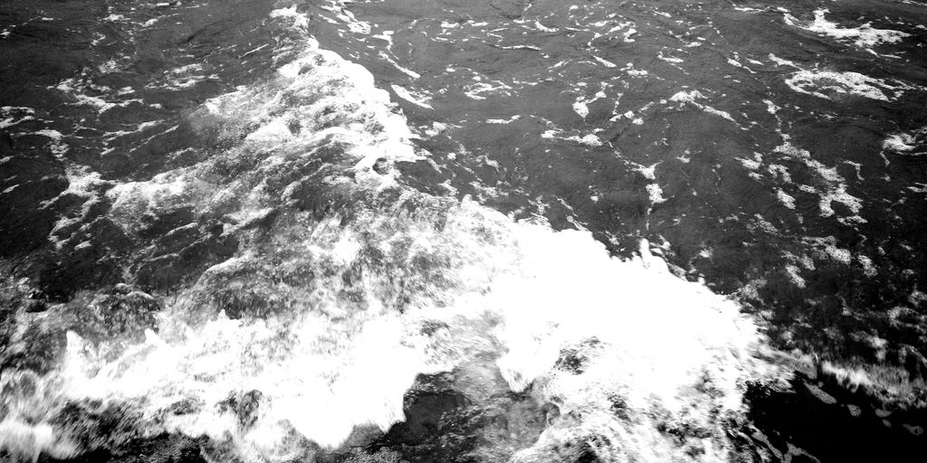 a black and white photo of a boat in the ocean