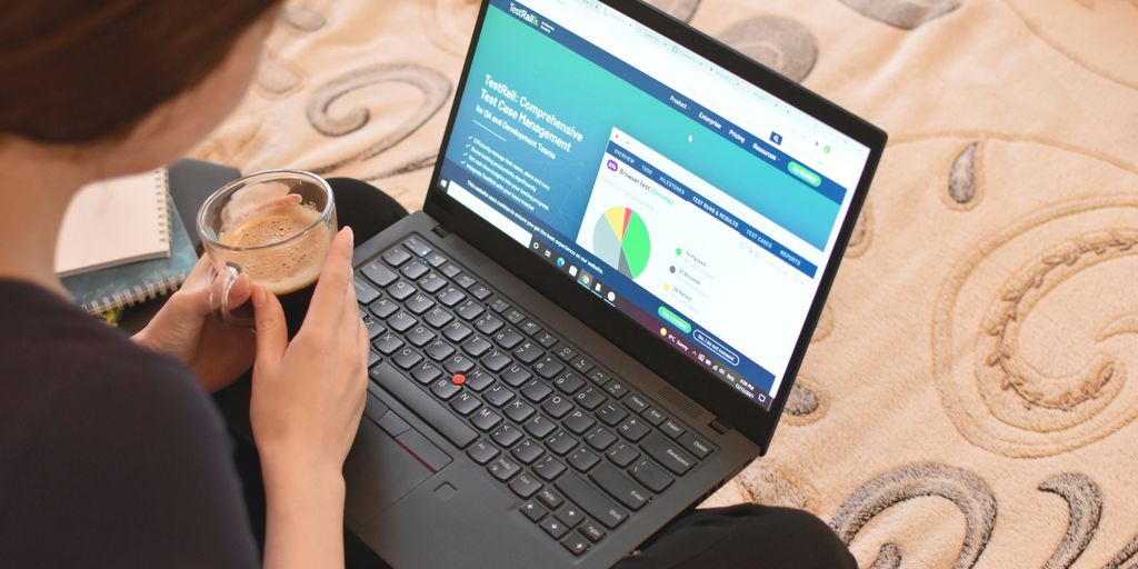 a woman sitting on a bed looking at a laptop